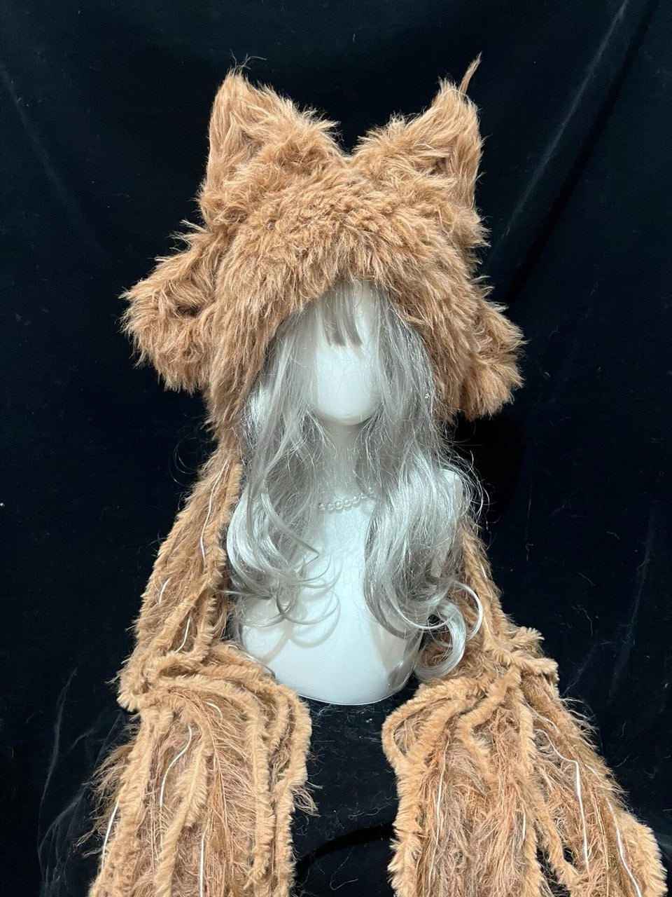 handmade crochet cottagecore fox ear hood in shaggy light camel yarn, featuring tall pointed ears and long braided ties, a cozy winter animal hat for daily wear