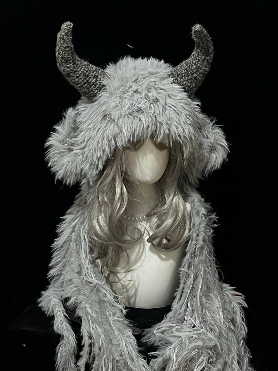 handmade crochet gothic goat horn hood in silver and gray shaggy texture with dark gray curved horns, dark fantasy cosplay accessory