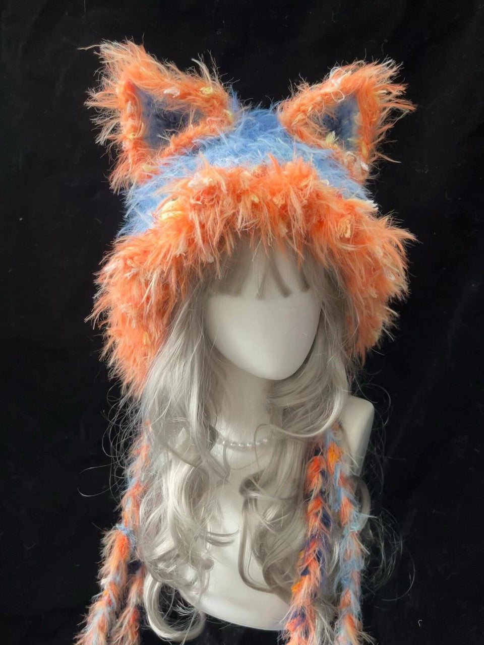 handmade crochet y2k fox ear hat in bright orange and blue shaggy texture with long braided ties, rave festival accessory