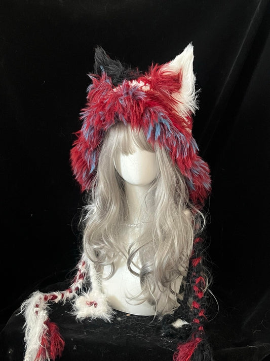 handmade crochet harlequin fox ear hood in bold red, white, blue and black shaggy texture, with long braided ties for circus cosplay and festival looks