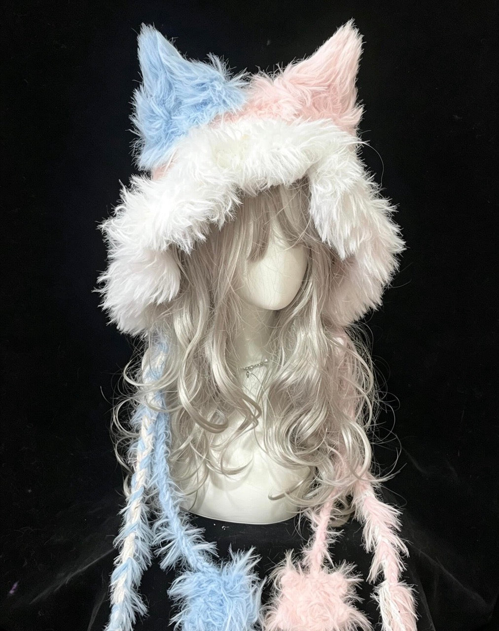 handmade crochet kawaii fox ear hood in pastel blue and pink shaggy texture, with long braided ties and soft pompom ends, whimsical winter headwear