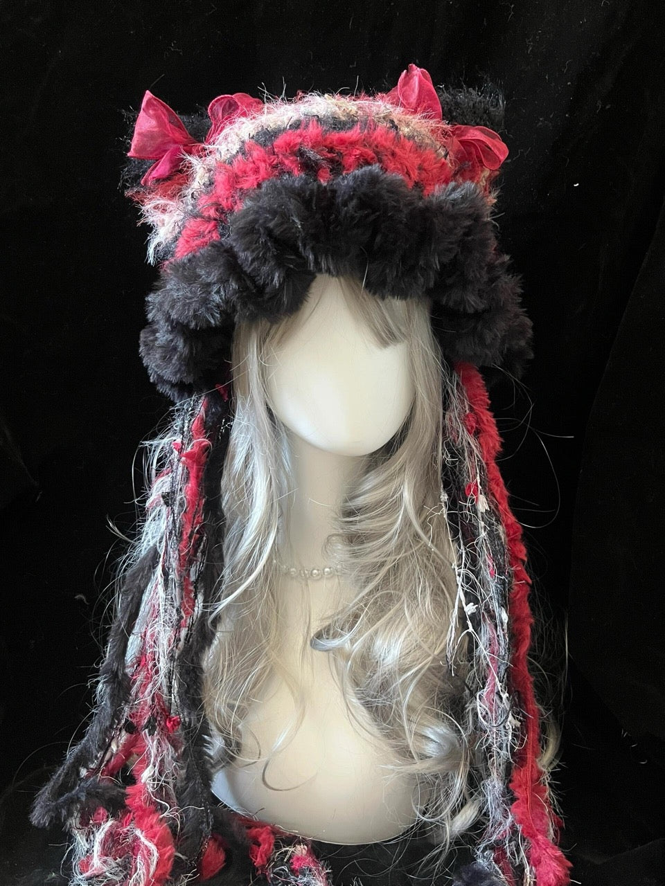 handmade crochet gothic coquette cat ear hat in red and black shaggy texture with satin ribbon bows and long mixed-yarn tassels, a dark fairycore winter hat