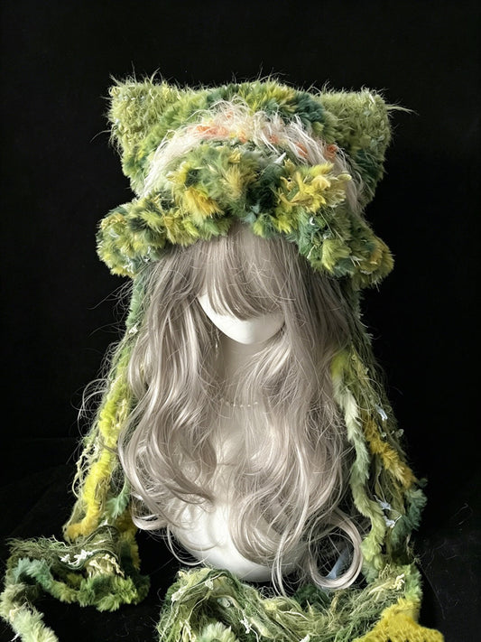 handmade crochet goblincore cat ear hat in green and yellow floral shaggy texture, with tall pointed ears and long textured ties, a woodland cosplay accessory
