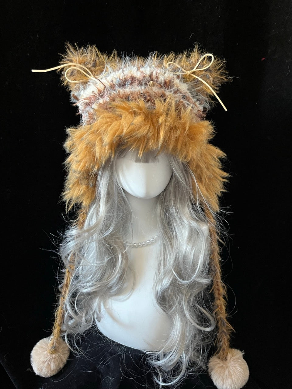 handmade crochet cottagecore cat ear hat in light camel shaggy faux fur, featuring a ribbon bow and long braided ties with fluffy pompom ends