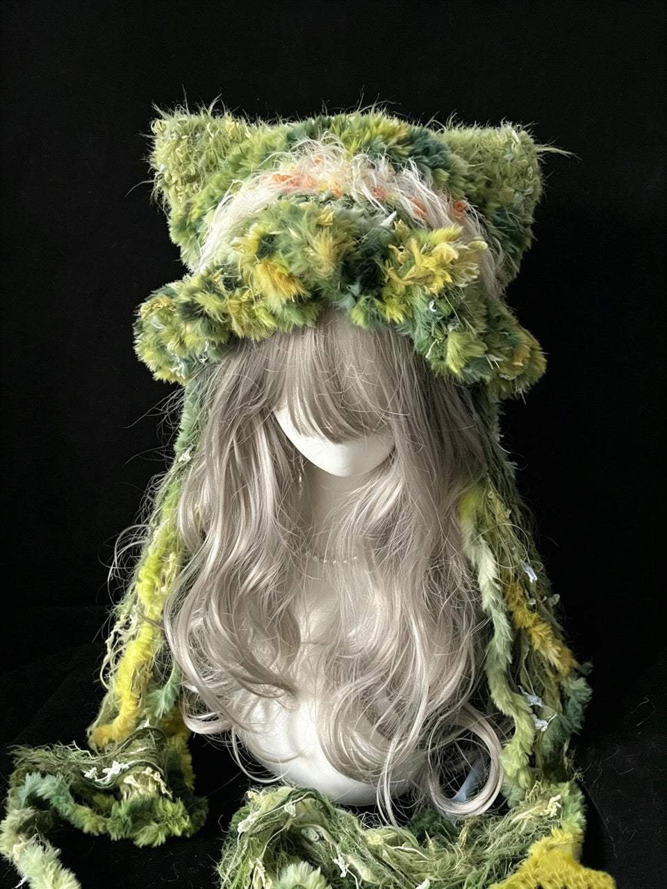 handmade crochet goblincore cat ear hat in green and yellow floral shaggy texture, with pointed ears and long textured ties, a woodland festival accessory