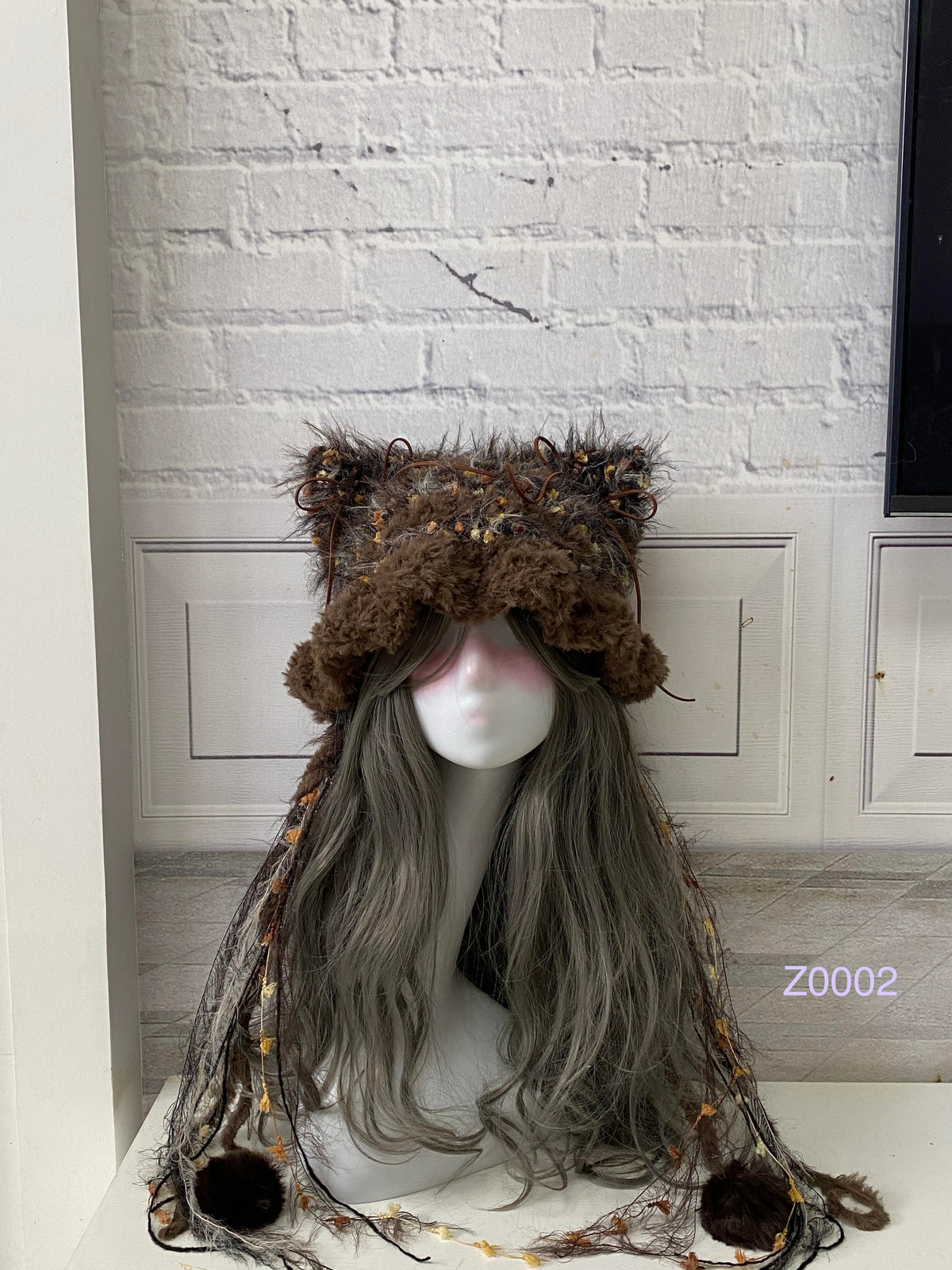 handmade crochet woodland goblincore cat ear hat in dark brown floral textured yarn with pointed ears and plush pompom ties. Cottagecore headwear for cosplay, festival and photoshoot styling