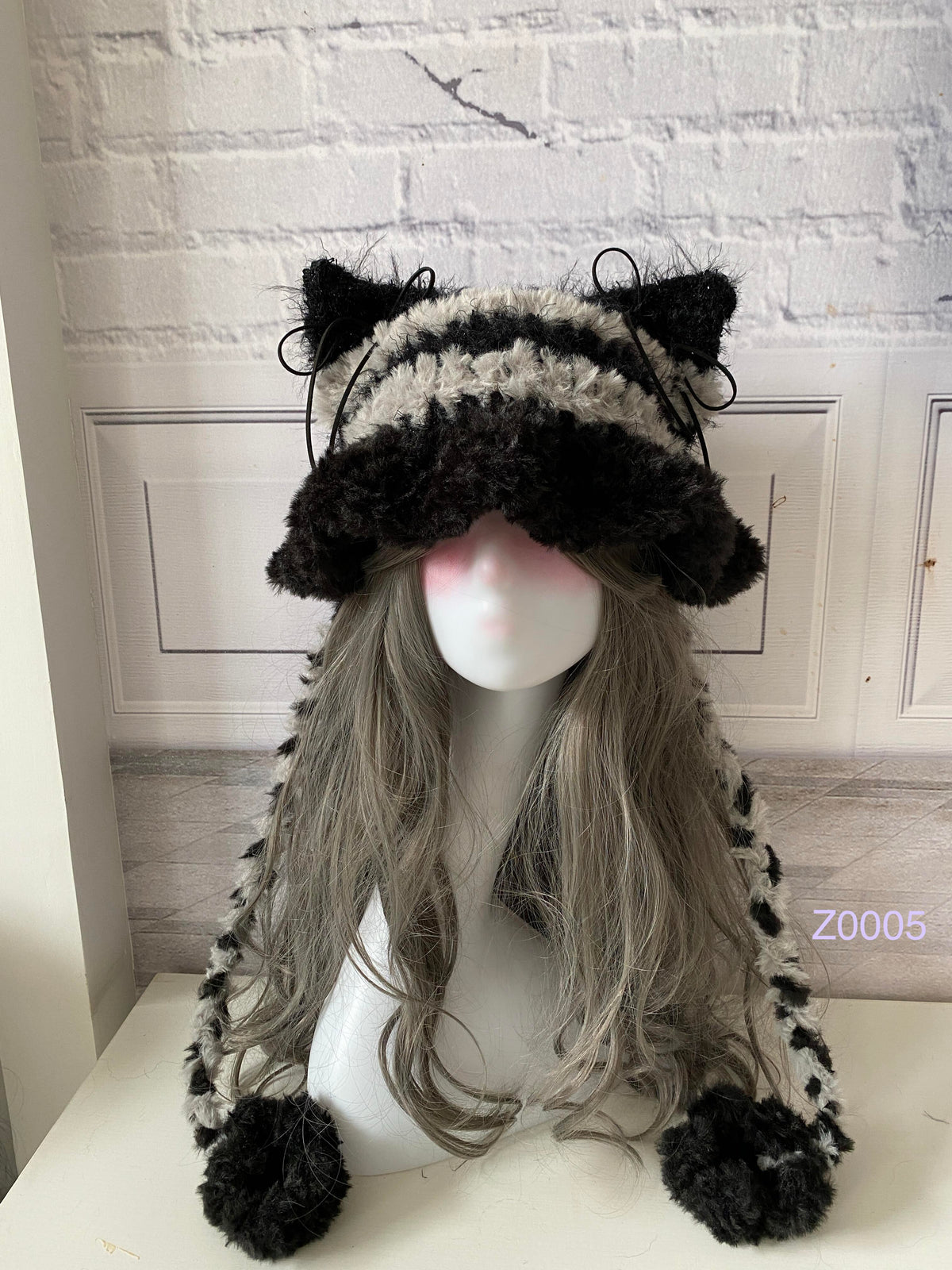 handmade crochet grunge monochrome cat ear hat in black and white striped fluffy texture with pointed ears, black satin ribbons and plush pompom ends. Dark fairy cosplay headwear for rave party and winter photoshoots