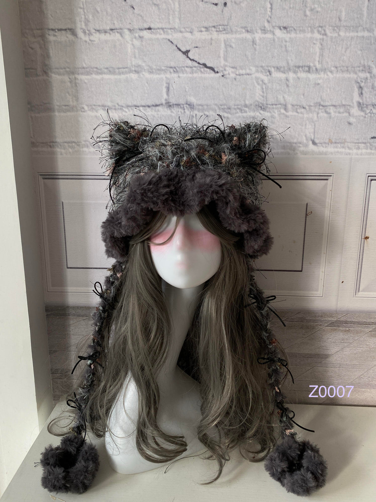 handmade crochet goth dark fairy cat ear hat in gray and pink floral textured yarn with pointed ears, black satin ribbons and plush pompom ties. Whimsical cosplay headwear for rave party and winter photoshoots