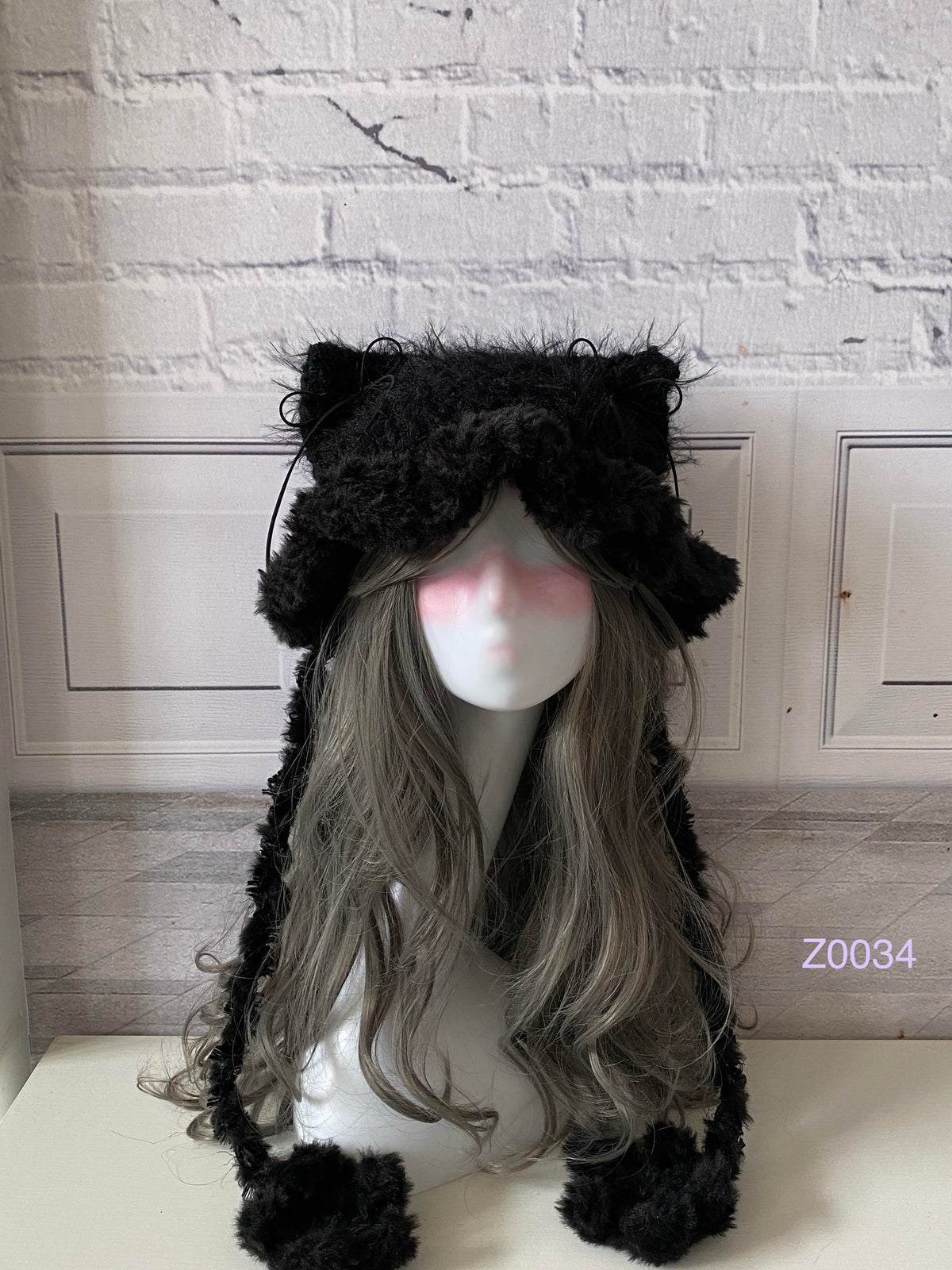 handmade crochet goth dark fairy cat ear hat in deep black fluffy texture with pointed ears and black pompom ties. Whimsical cosplay headwear for rave party and winter photoshoots