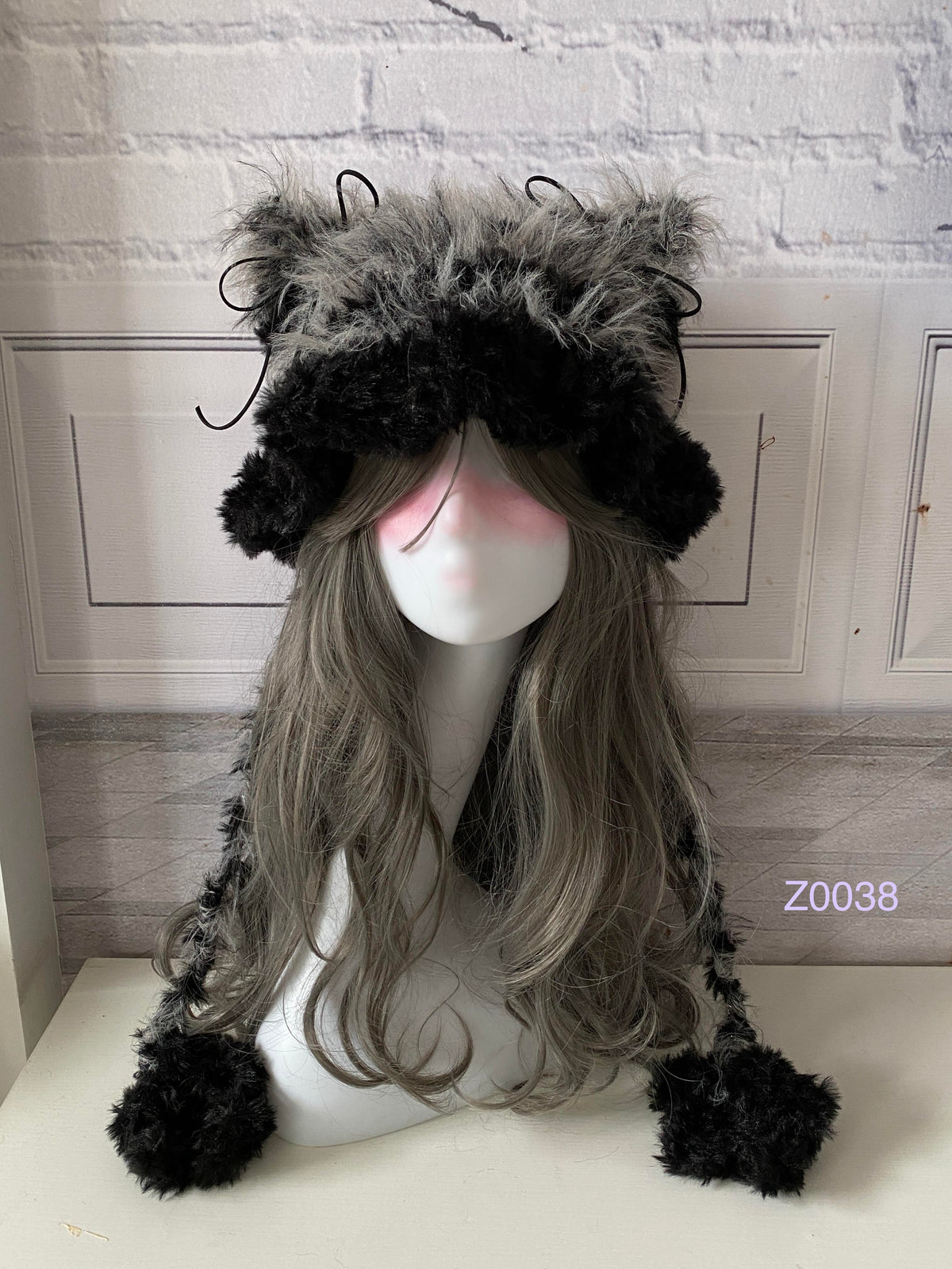 handmade crochet goth monochrome cat ear hat in black and gray fluffy contrast with pointed ears and black pompom ends. Dark fairy cosplay headwear for rave party and winter photoshoots
