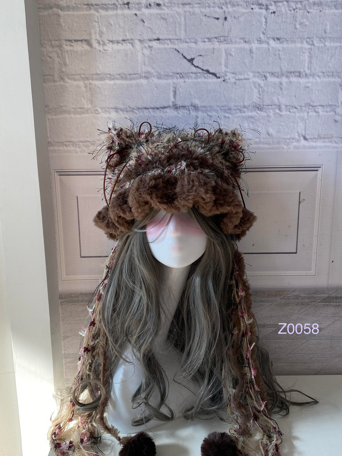 handmade crochet woodland goblincore cat ear hat in brown and pink floral textured yarn with pointed ears and plush pompom ties. Cottagecore headwear for cosplay, festival and photoshoot styling