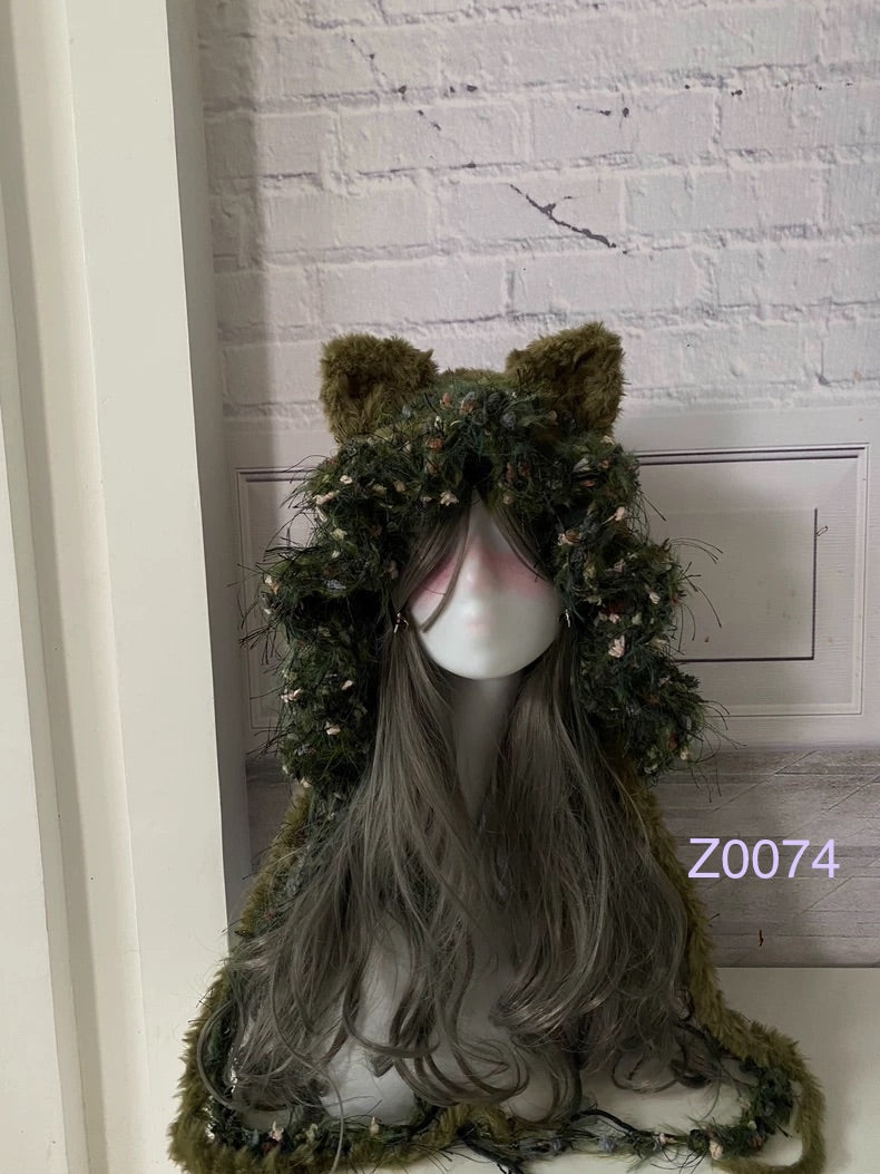 handmade crochet goblincore woodland cat ear hood in olive green floral textured yarn with long trailing strands and earthy accents. Cottagecore headwear for cosplay, music festival and photoshoot styling