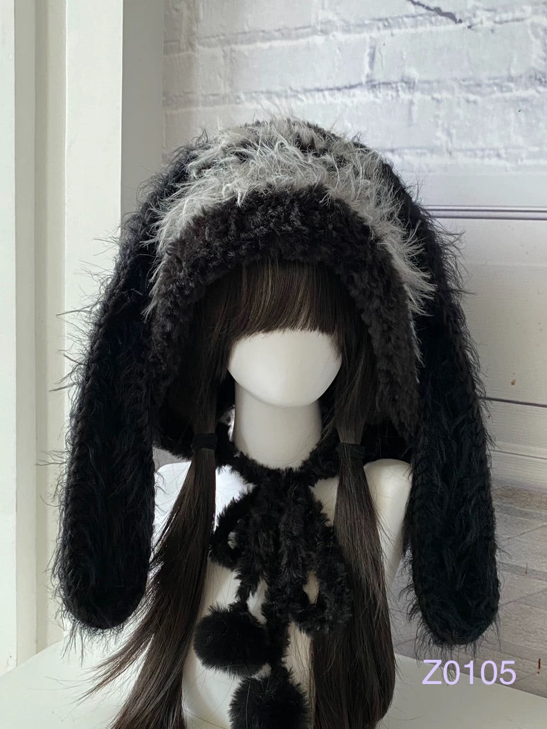 handmade crochet goth dark fairy bunny ear hood in deep black fluffy texture with long floppy ears, black ribbon ties and plush pompom ends. Dark fairy cosplay headwear for rave party and winter photoshoots