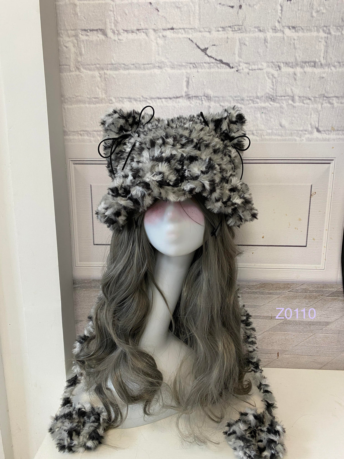 handmade crochet grunge monochrome cat ear hat in black and white leopard print fluffy texture with pointed ears and long trailing ties. Dark fairy cosplay headwear for rave party and winter photoshoots