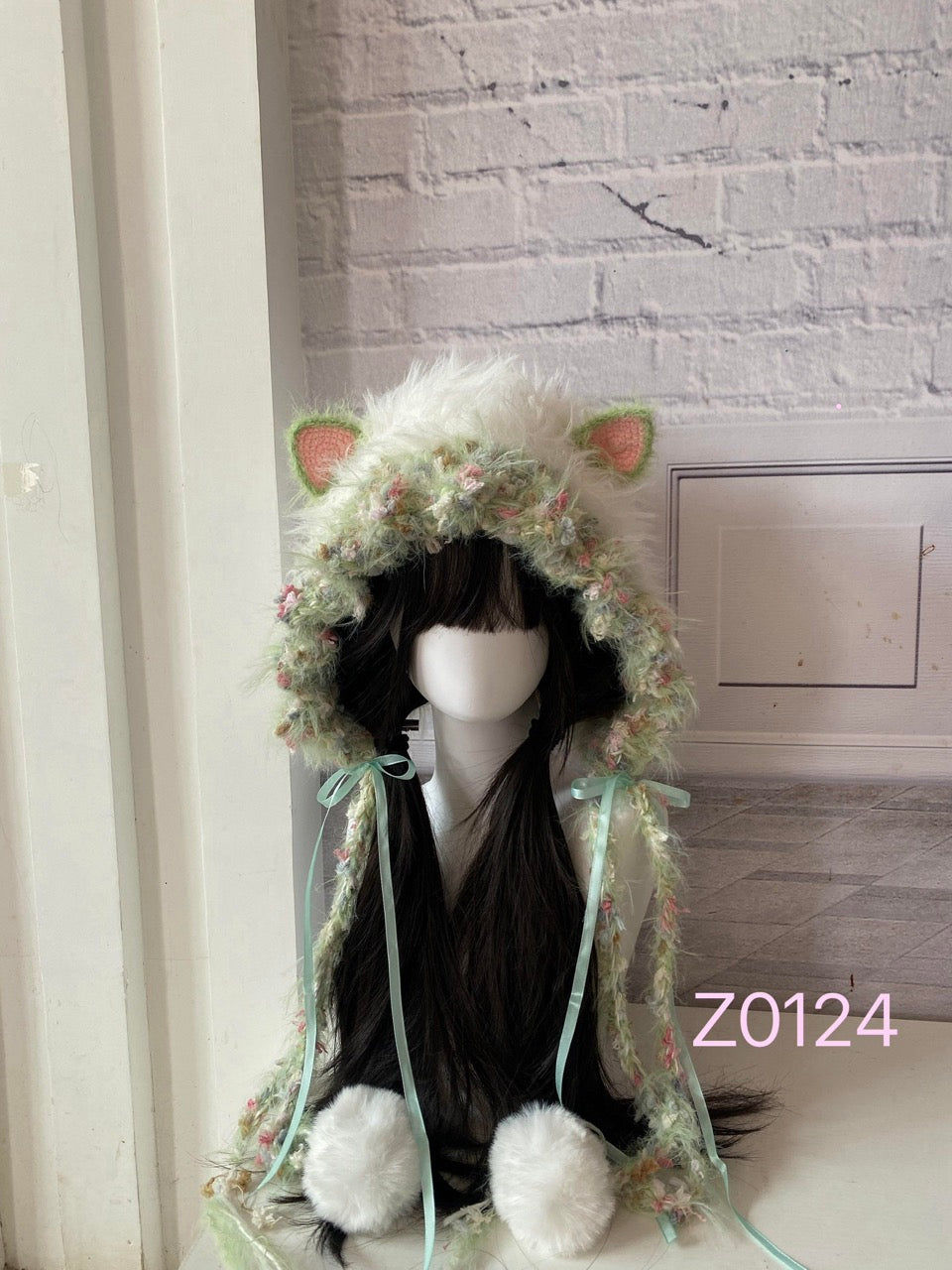handmade crochet fairycore cottagecore cat ear hood in mint green and soft pink floral textured yarn, mint satin ribbons and white pompom ties. Whimsical woodland headwear for cosplay, photoshoot prop and gift idea