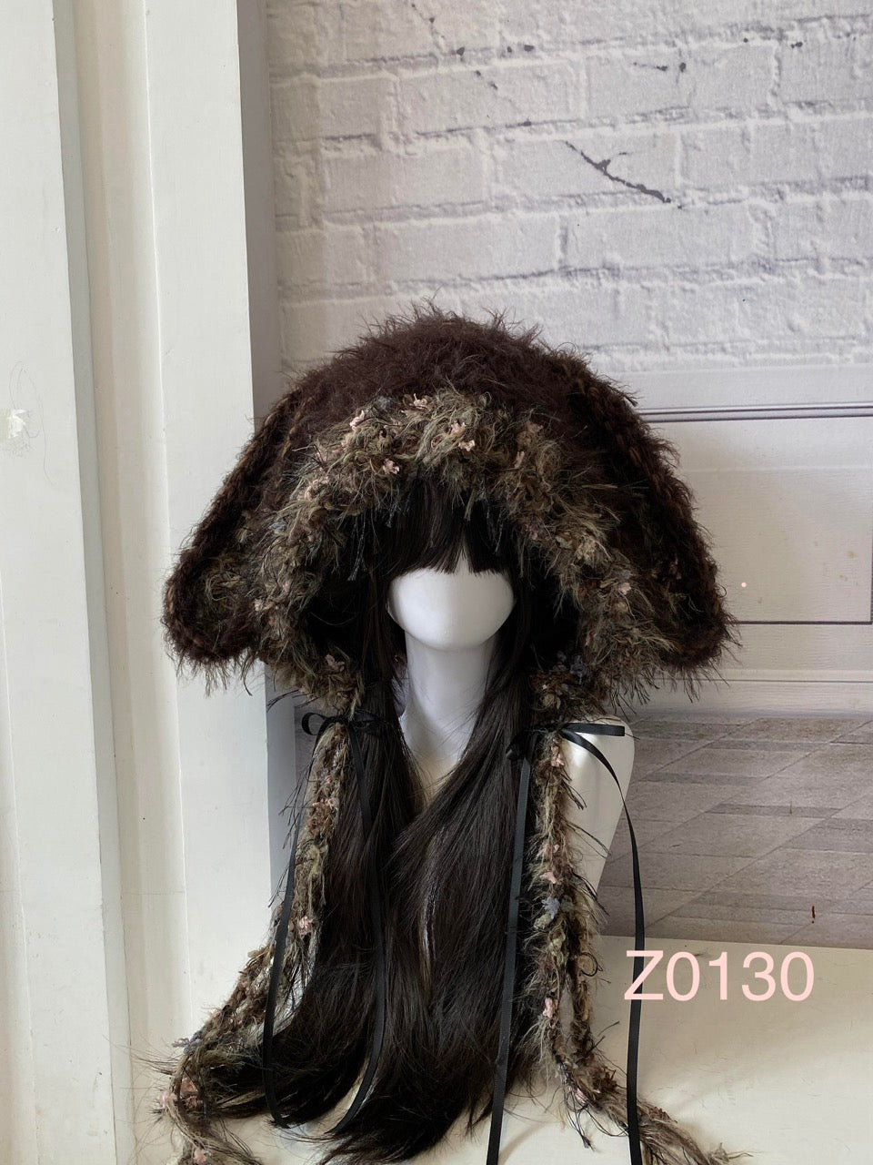 handmade crochet cottagecore mori girl bunny ear hood in dark brown floral textured yarn with long trailing strands and black ribbon ties. Woodland whimsical headwear for cosplay, festival and photoshoot styling