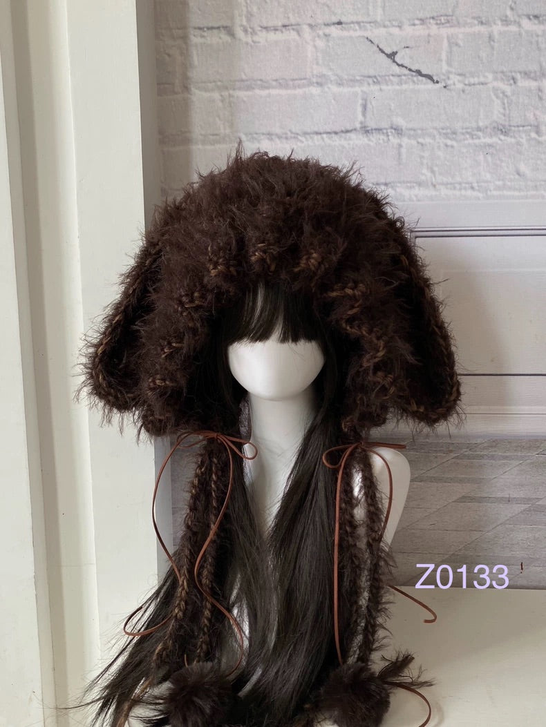 handmade crochet woodland mori girl bunny ear hood in dark brown braided textured yarn with brown satin ribbon ties and fur pompom ends. Cottagecore headwear for cosplay, winter festival and photoshoot styling