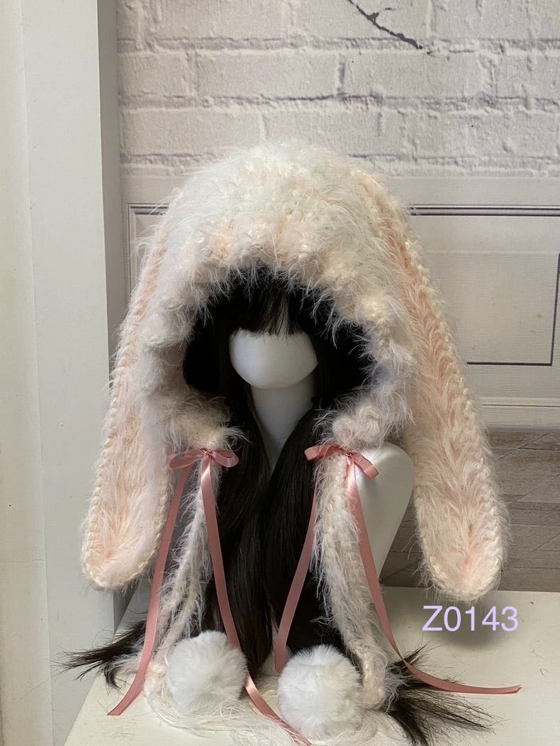handmade crochet coquette dollette bunny ear hood in fluffy cream and pale pink, pink satin ribbon bows and white pompom ties. Sweet fairycore headwear for cosplay, winter festival and romantic photoshoots