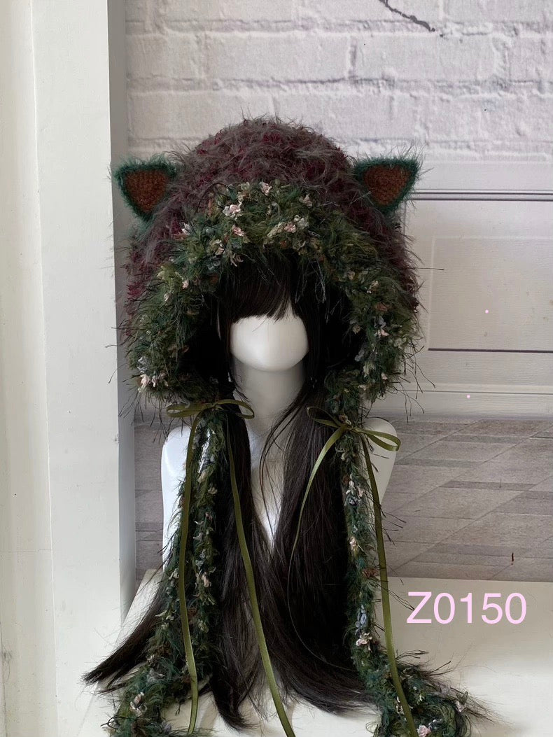 handmade crochet goblincore woodland cat ear hood in dark green floral textured yarn with olive satin ribbon ties and long trailing strands. Cottagecore headwear for cosplay, music festival and photoshoot styling