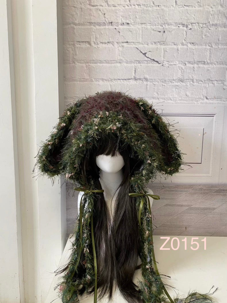 handmade crochet goblincore woodland bunny ear hood in dark green floral textured yarn with mossy tones and olive satin ribbon ties. Cottagecore headwear for cosplay, music festival and photoshoot styling
