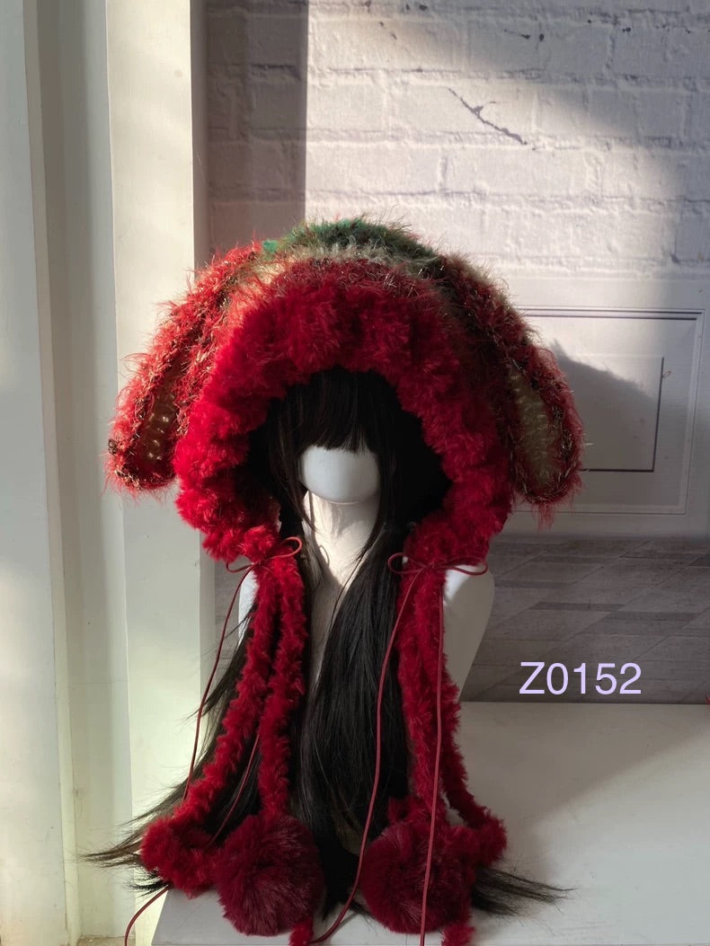 handmade crochet Christmas festive bunny ear hood in bold red and green fluffy contrast, red satin ribbons and fur pompom ends. Holiday party headwear for cosplay, new year celebration and winter festival styling