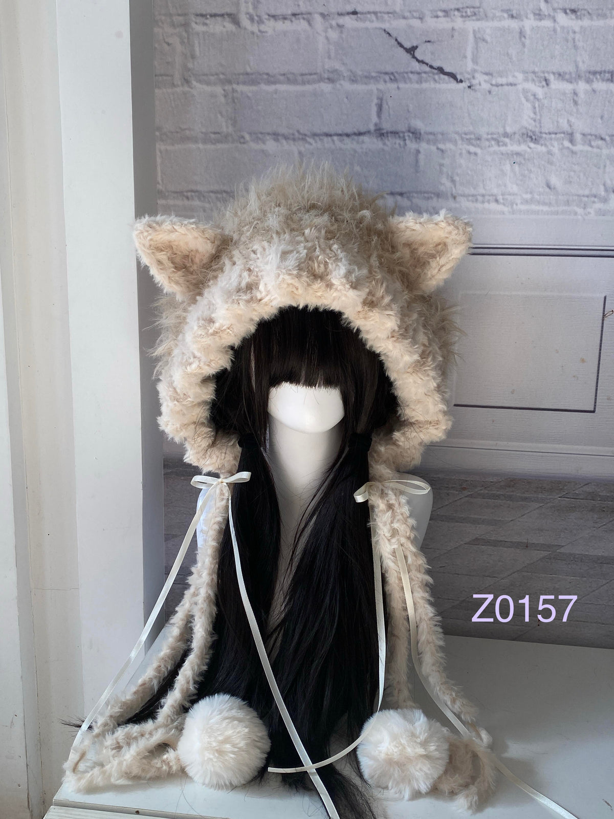 handmade crochet coquette cottagecore cat ear hood in cream and tan fluffy contrast with pointed ears, white satin ribbons and plush pompom ties. Sweet winter headwear for cosplay, photoshoot prop and gift idea