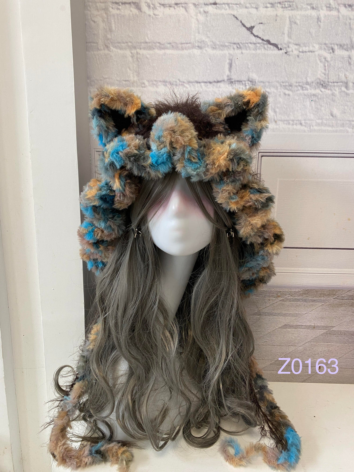 handmade crochet woodland goblincore cat ear hood in brown and blue mixed fluffy texture with pointed ears and long trailing ties. Cottagecore headwear for cosplay, music festival and photoshoot styling