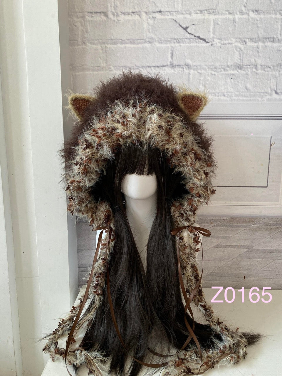 handmade crochet woodland mori girl cat ear hood in dark brown and light brown textured yarn with brown satin ribbons and long trailing details. Cottagecore headwear for cosplay, festival and photoshoots