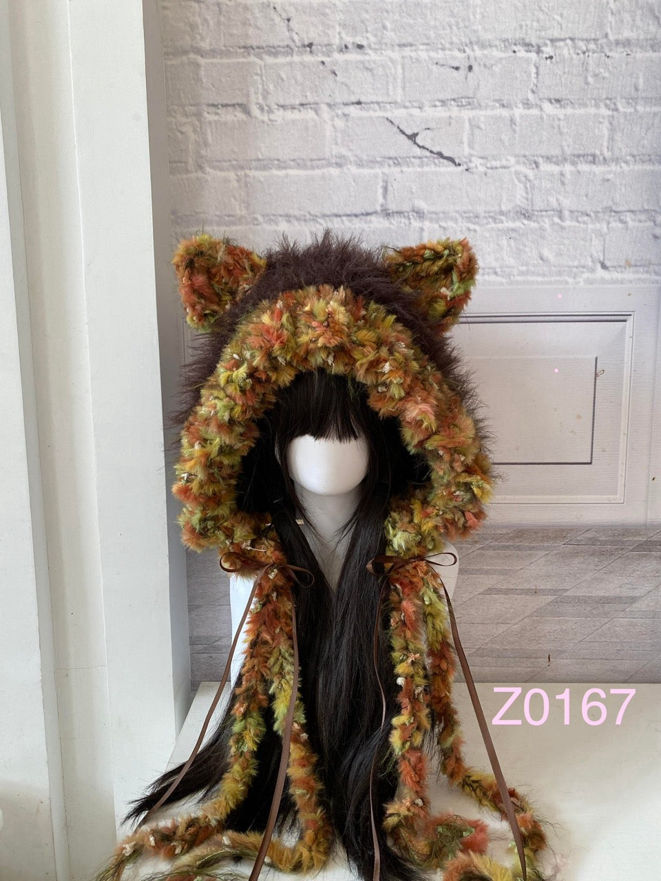handmade crochet woodland cottagecore cat ear hood in dark brown and cream fluffy contrast, brown satin ribbons and fur pompom ties. Mori girl style headwear for cosplay, winter festival and photoshoots