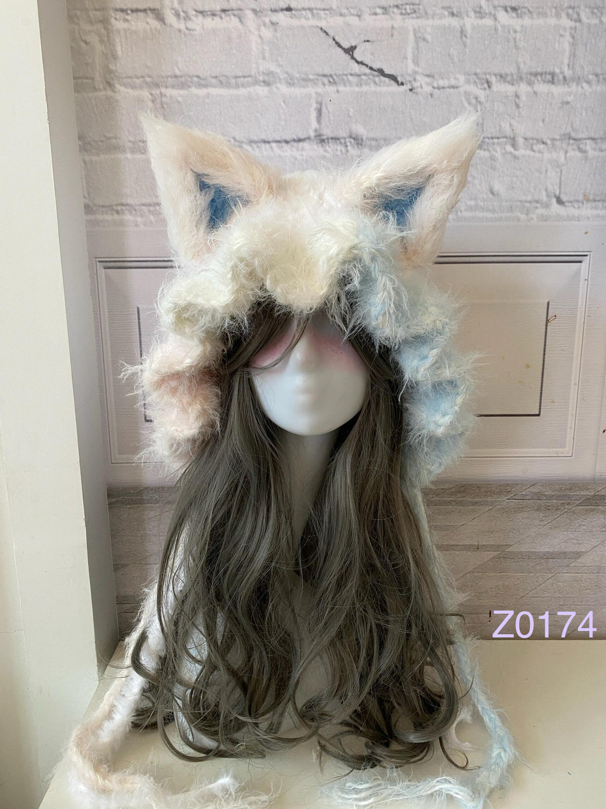 handmade crochet fairycore kawaii fox ear hood in cream and pale blue fluffy texture with pointed ears and soft trailing ties. Whimsical winter headwear for cosplay, photoshoot prop and gift idea