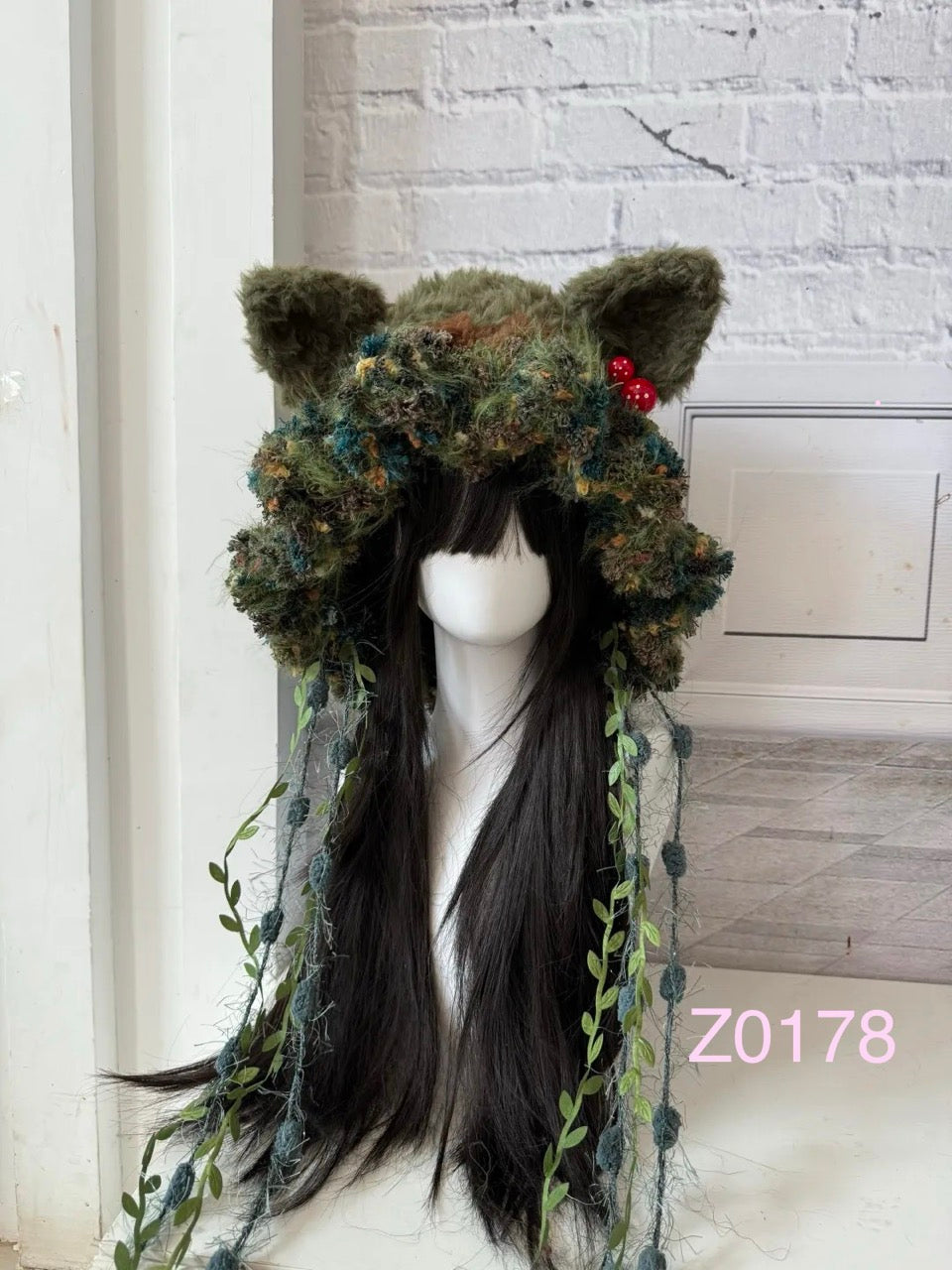 handmade crochet goblincore mushroomcore cat ear hat in forest green moss and floral textured yarn with tiny red mushroom accents and leafy vine ties. Woodland cottagecore headwear for cosplay, music festival and photoshoot styling