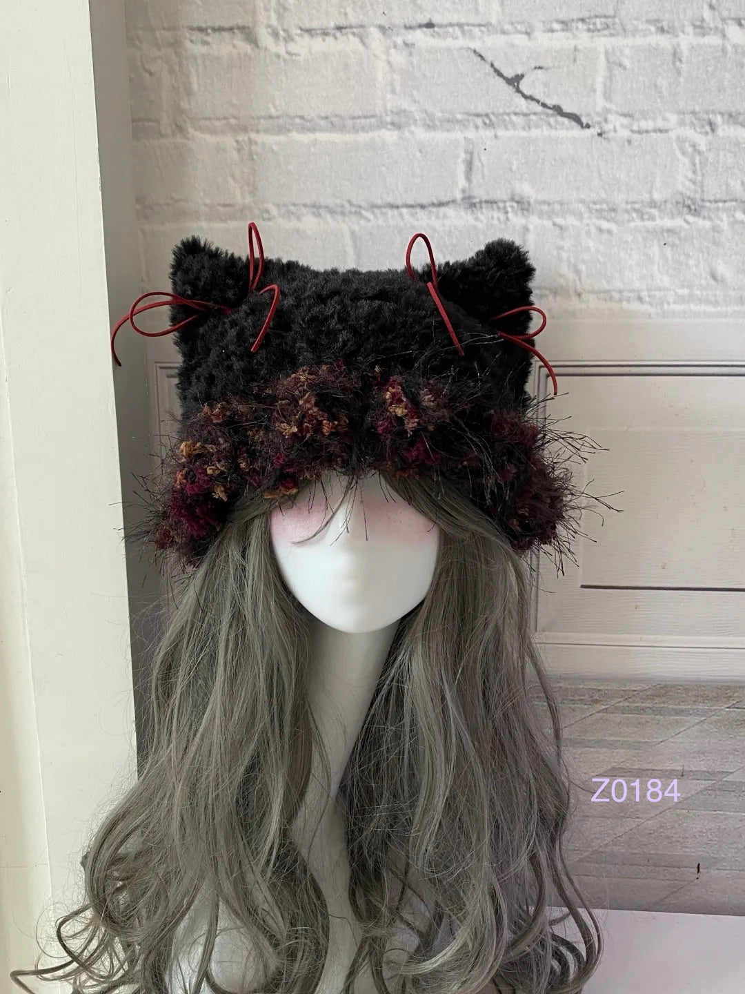 handmade crochet goth dark fairy cat ear hat in black and red floral textured yarn with pointed ears and long trailing ties. Whimsical cosplay headwear for rave party and winter photoshoots