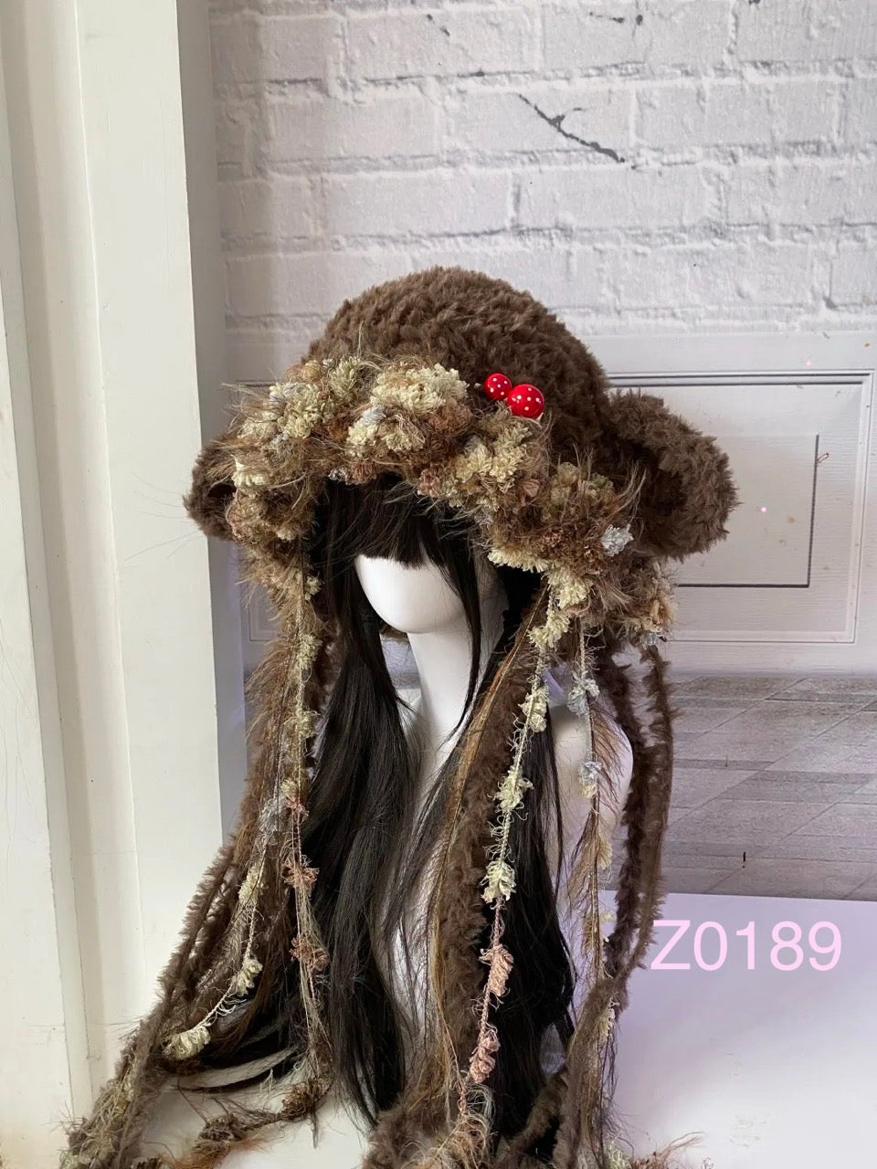 handmade crochet goblincore mushroomcore jellyfish sheep ear hat in dark brown and moss textured yarn with tiny red mushroom accents and long trailing strands. Whimsical woodland headwear for cosplay, festival and photoshoot styling