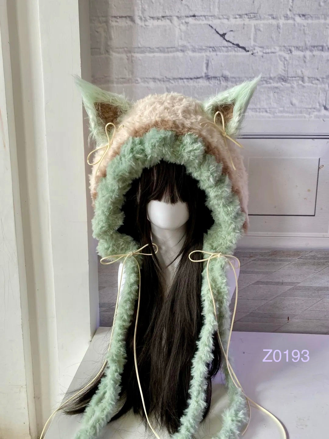handmade crochet fairycore cottagecore fox ear hood in mint green and soft brown fluffy texture with pointed ears, cream satin ribbons and long trailing ties. Woodland whimsical headwear for cosplay, photoshoot prop and gift idea
