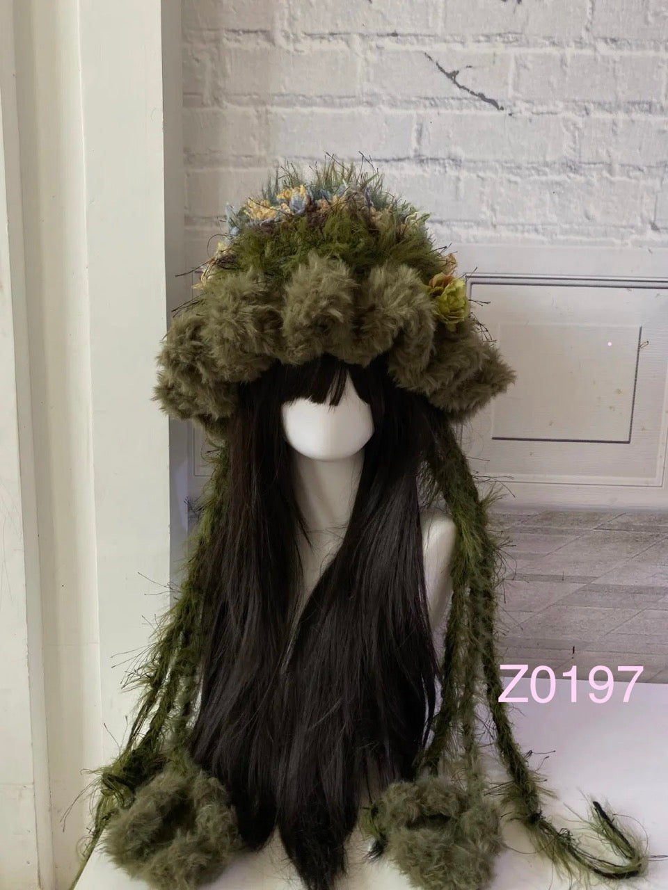 handmade crochet goblincore woodland jellyfish cat ear hat in olive green and floral textured yarn with long trailing cat paw strands and soft woodland accents. Cottagecore headwear for cosplay, music festival and photoshoot styling