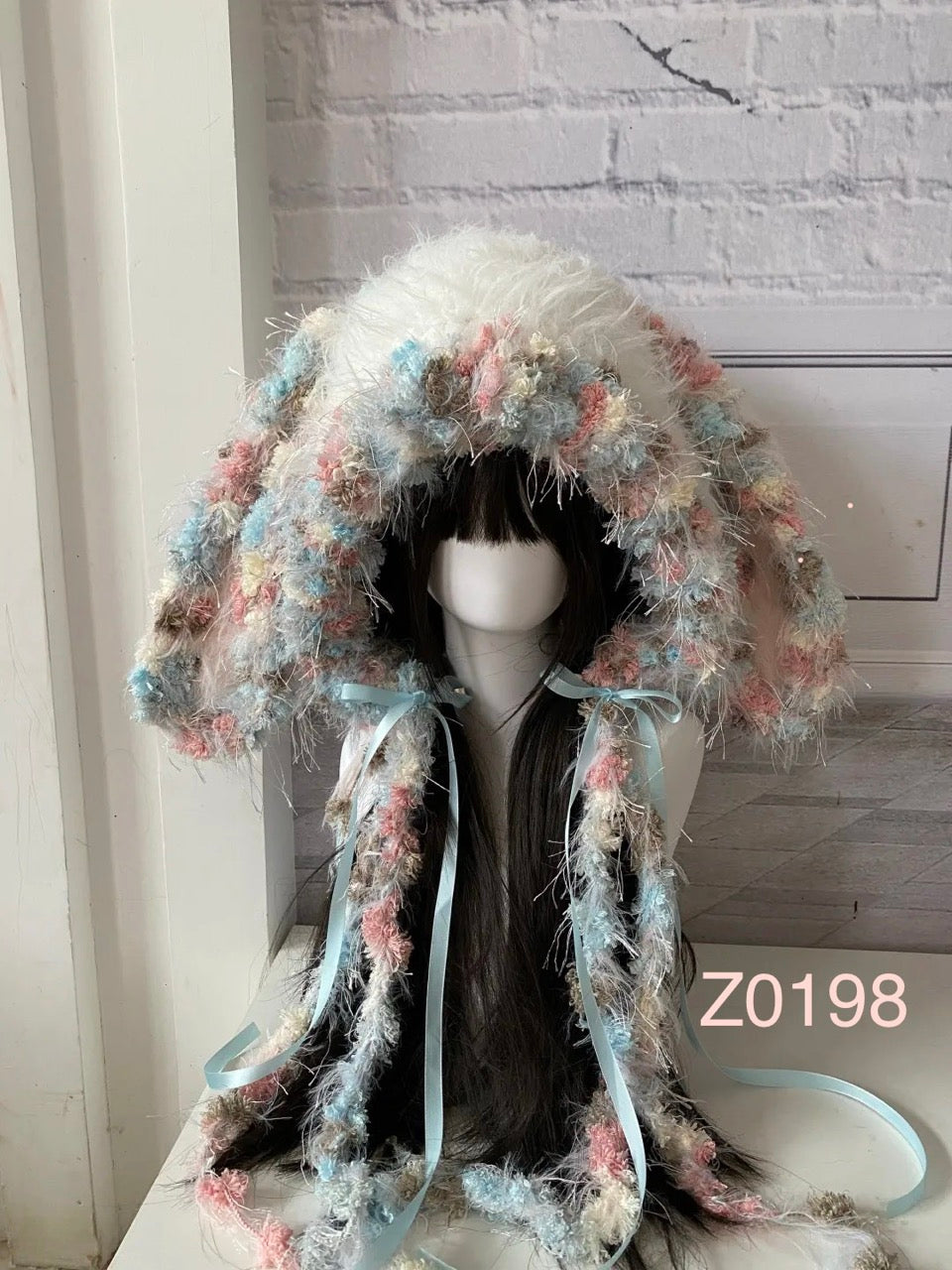 handmade crochet fairycore coquette bunny ear hood in pastel pink, blue and cream floral textured yarn with light blue satin ribbons. Kawaii cosplay headwear for photoshoot prop and gift idea