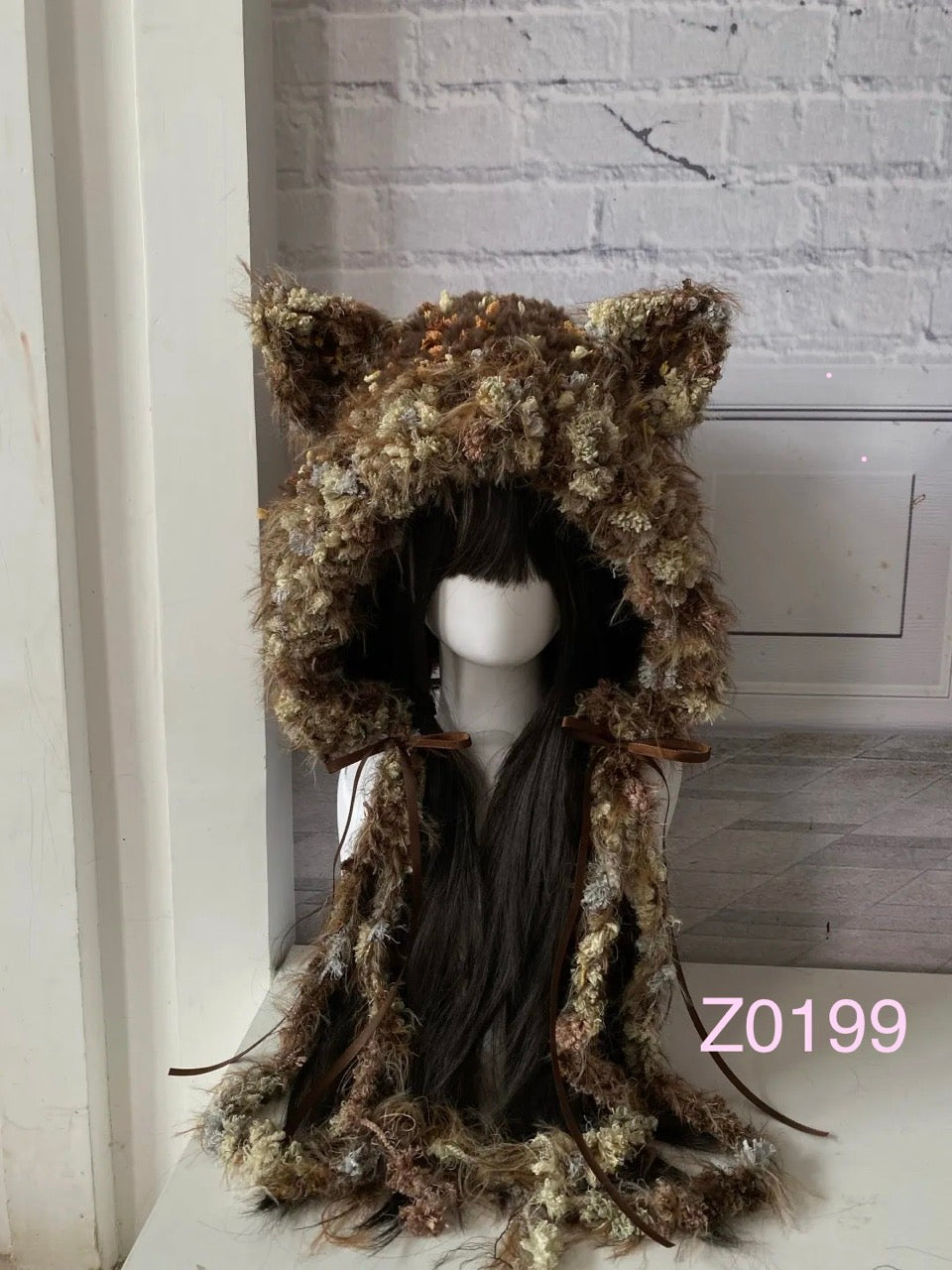 handmade crochet cottagecore mori girl cat ear hood in earthy brown floral textured yarn with brown satin ribbon ties and long trailing details. Woodland headwear for cosplay, festival and photoshoot styling
