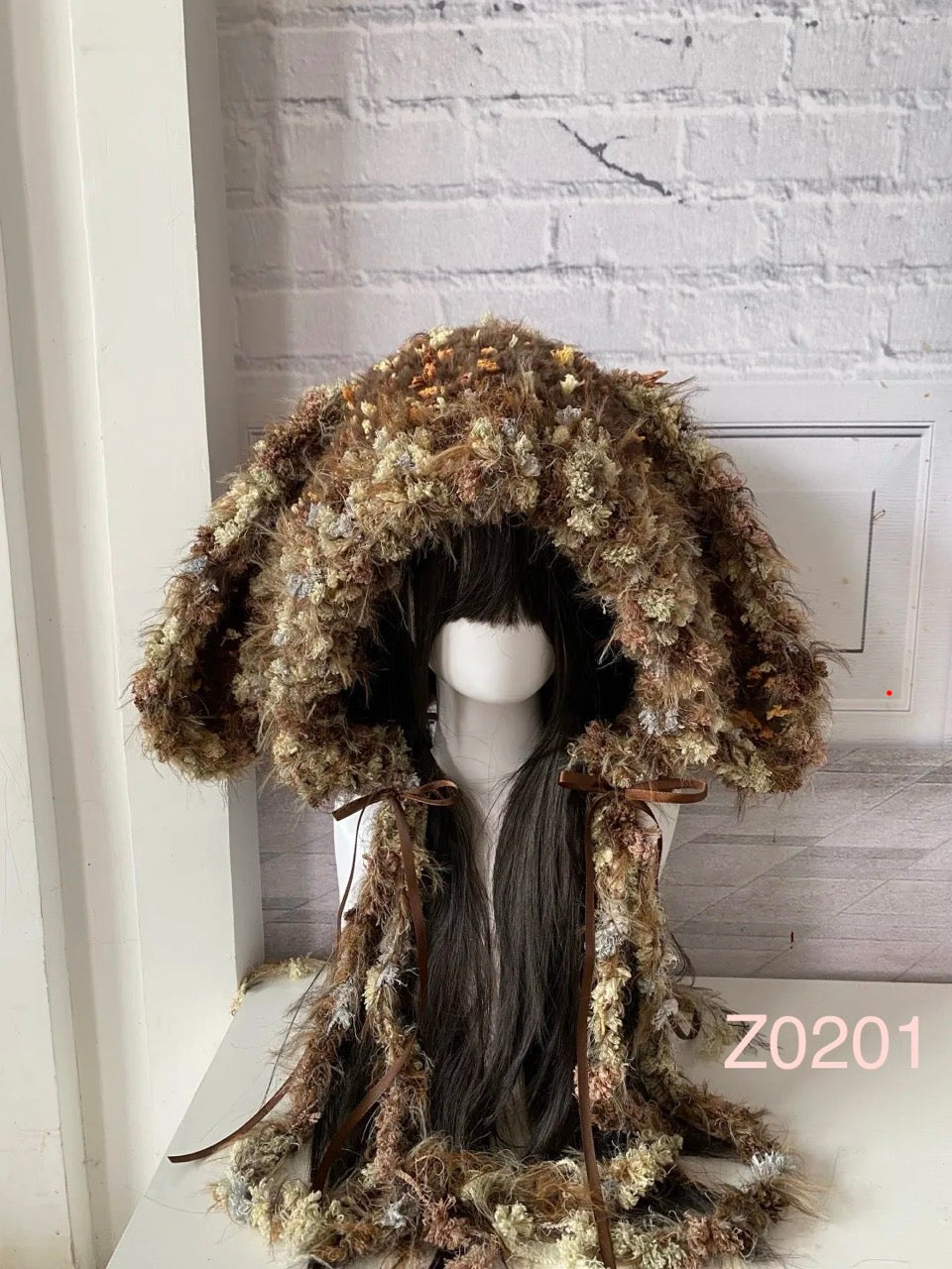 handmade crochet cottagecore woodland bunny ear hood in earthy brown floral textured yarn with brown satin ribbon ties. Mori girl style headwear for festival and cosplay photoshoots