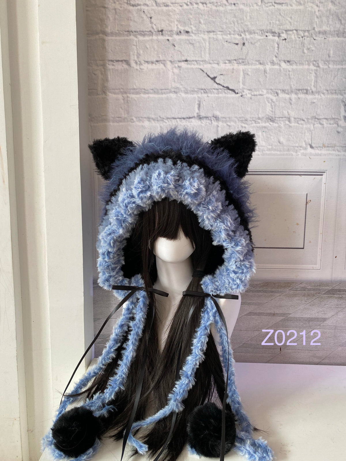 handmade crochet goth dark fairy cat ear hood in black and blue fluffy contrast with pointed ears, black satin ribbons and plush pompom ends. Whimsical cosplay headwear for rave party and winter photoshoots