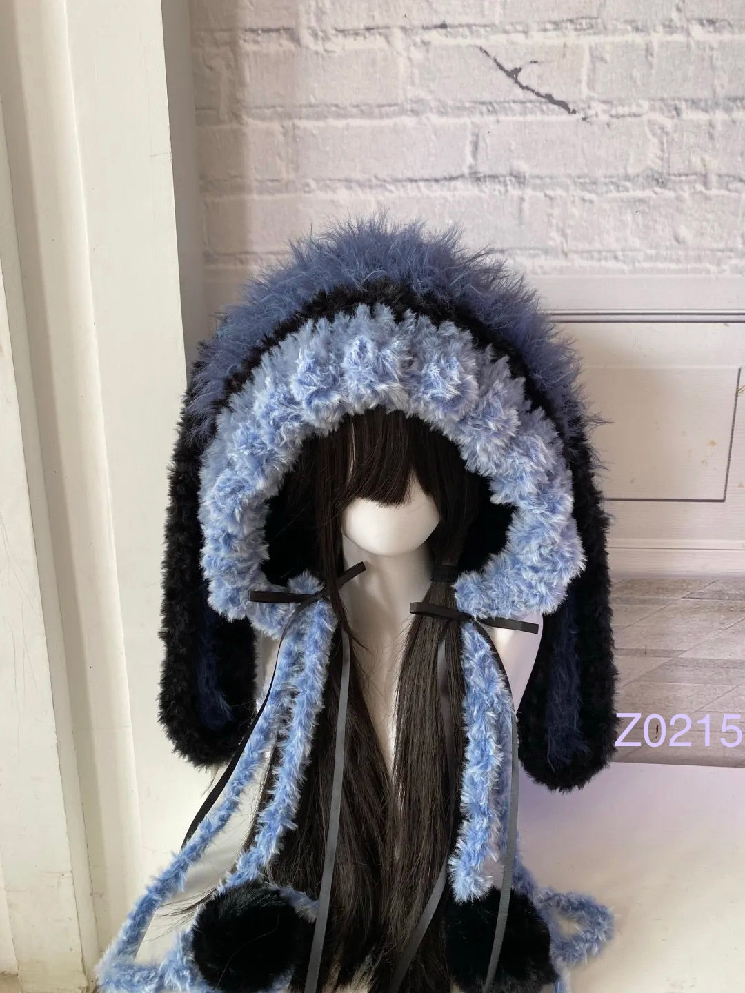 handmade crochet goth dark fairy bunny ear hood in black and blue fluffy contrast with long floppy ears, black satin ribbons and plush pompom ties. Whimsical cosplay headwear for rave party and winter photoshoots