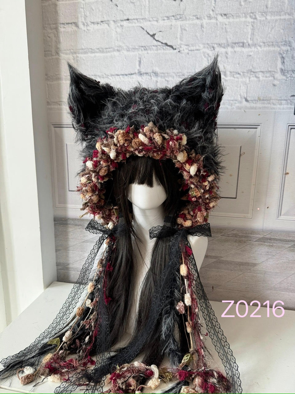 handmade crochet goth dark fairy fox ear hood in dark gray and red floral textured yarn with black lace ribbon details and pointed ears. Whimsical cosplay headwear for rave party, Halloween and photoshoot styling