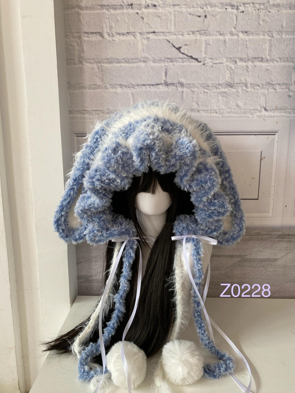 handmade crochet kawaii coquette bunny ear hood in blue and white striped fluffy texture with long floppy ears, white satin ribbons and plush pompom ties. Cozy winter headwear for cosplay, photoshoot prop and gift idea