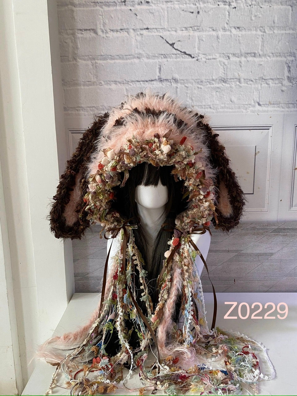 handmade crochet fairycore cottagecore bunny ear hood in pink and brown floral textured yarn with long tassel ribbons. Woodland whimsical headwear for festival, cosplay and photoshoot styling