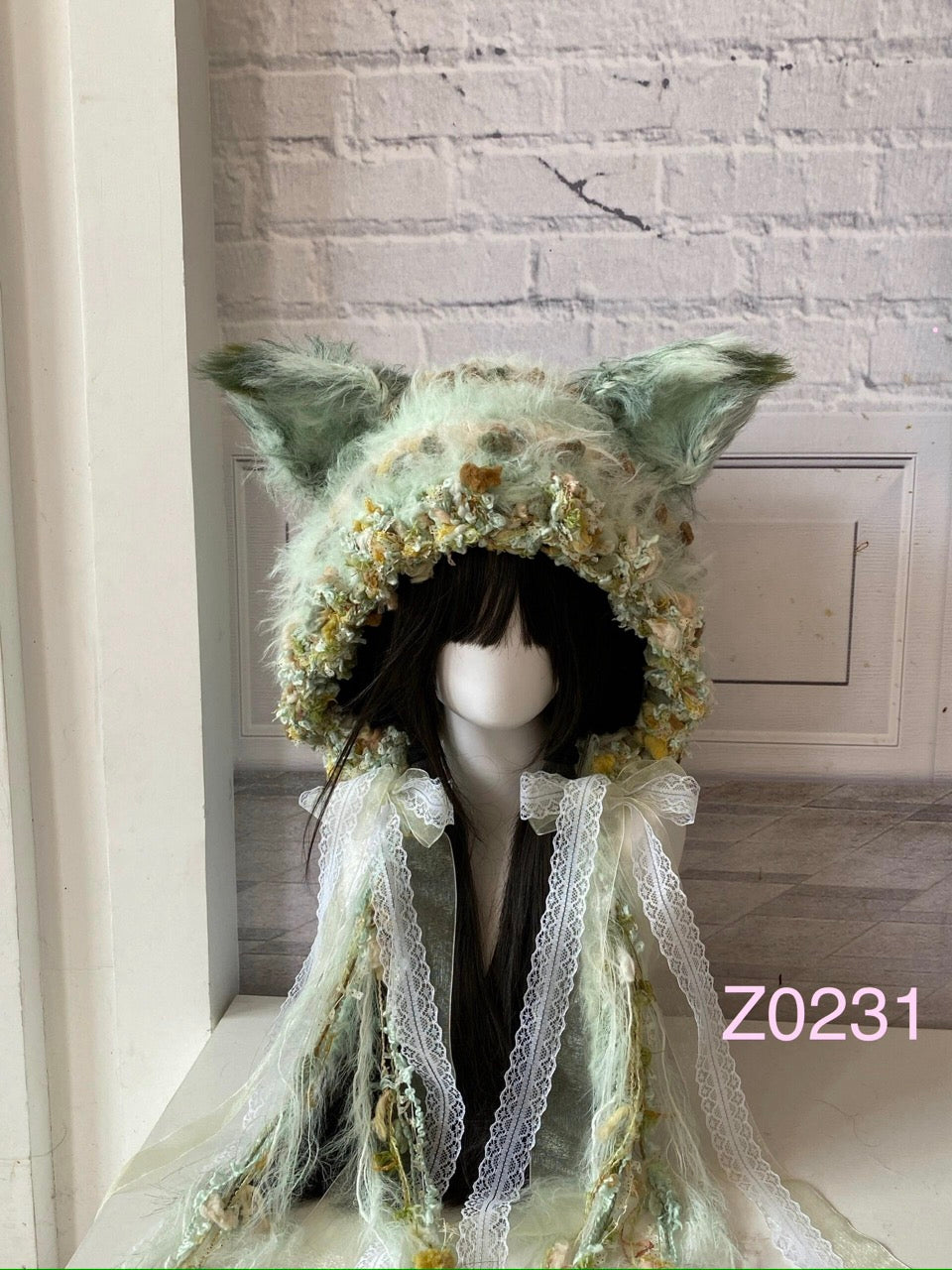 handmade crochet fairycore cottagecore fox ear hood in mint green floral textured yarn with delicate white lace ribbons and pointed ears. Whimsical woodland headwear for cosplay, photoshoot prop and romantic festival styling