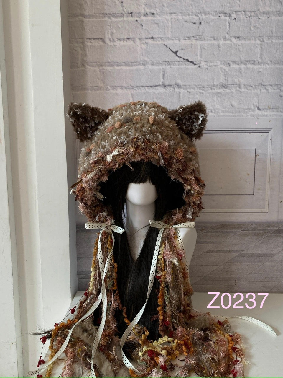 handmade crochet cottagecore mori girl cat ear hood in light brown floral mixed yarn with polka dot satin ribbon ties and long tassel details. Woodland whimsical headwear for cosplay, festival and photoshoot styling
