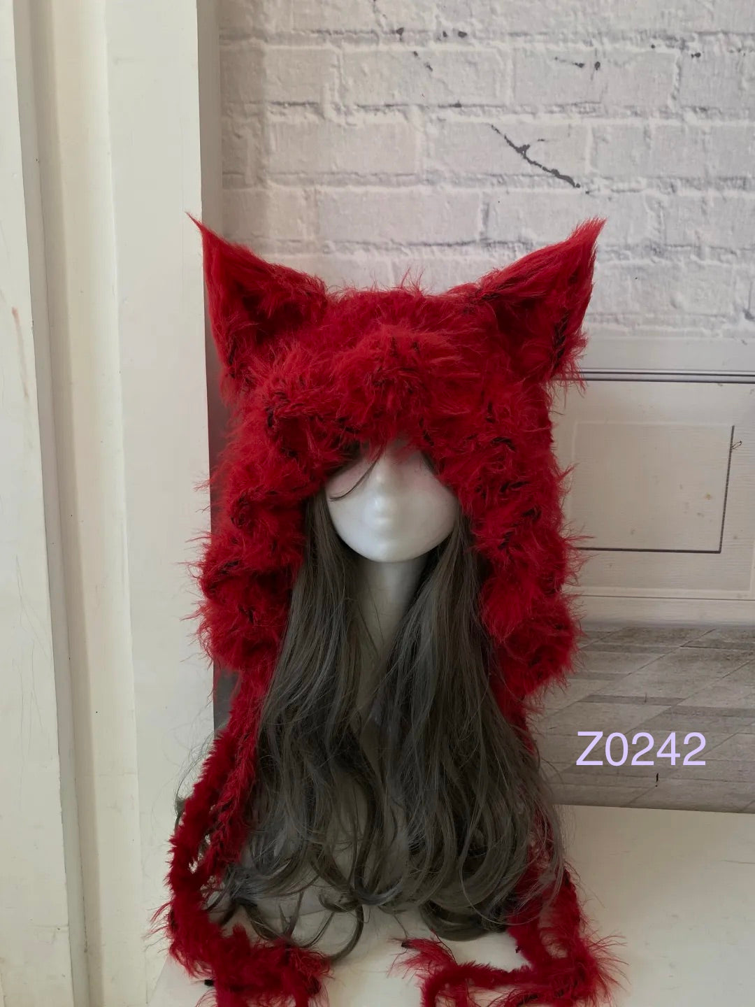 handmade crochet goth dark fairy fox ear hood in deep red fluffy texture with tall pointed ears and long trailing ties. Whimsical cosplay headwear for Halloween, rave party and winter photoshoots