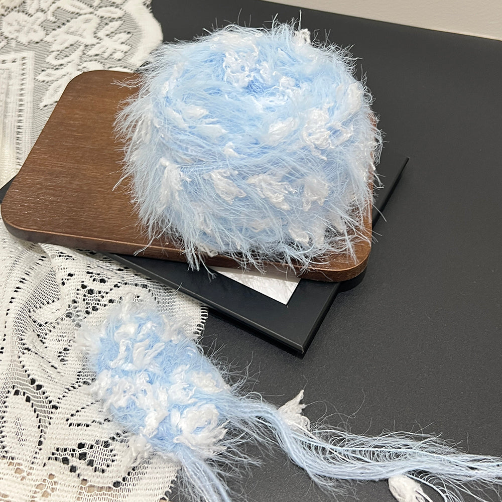 Minimal pale blue cloud cake yarn styled with white lace, cool tone pastel fancy art yarn