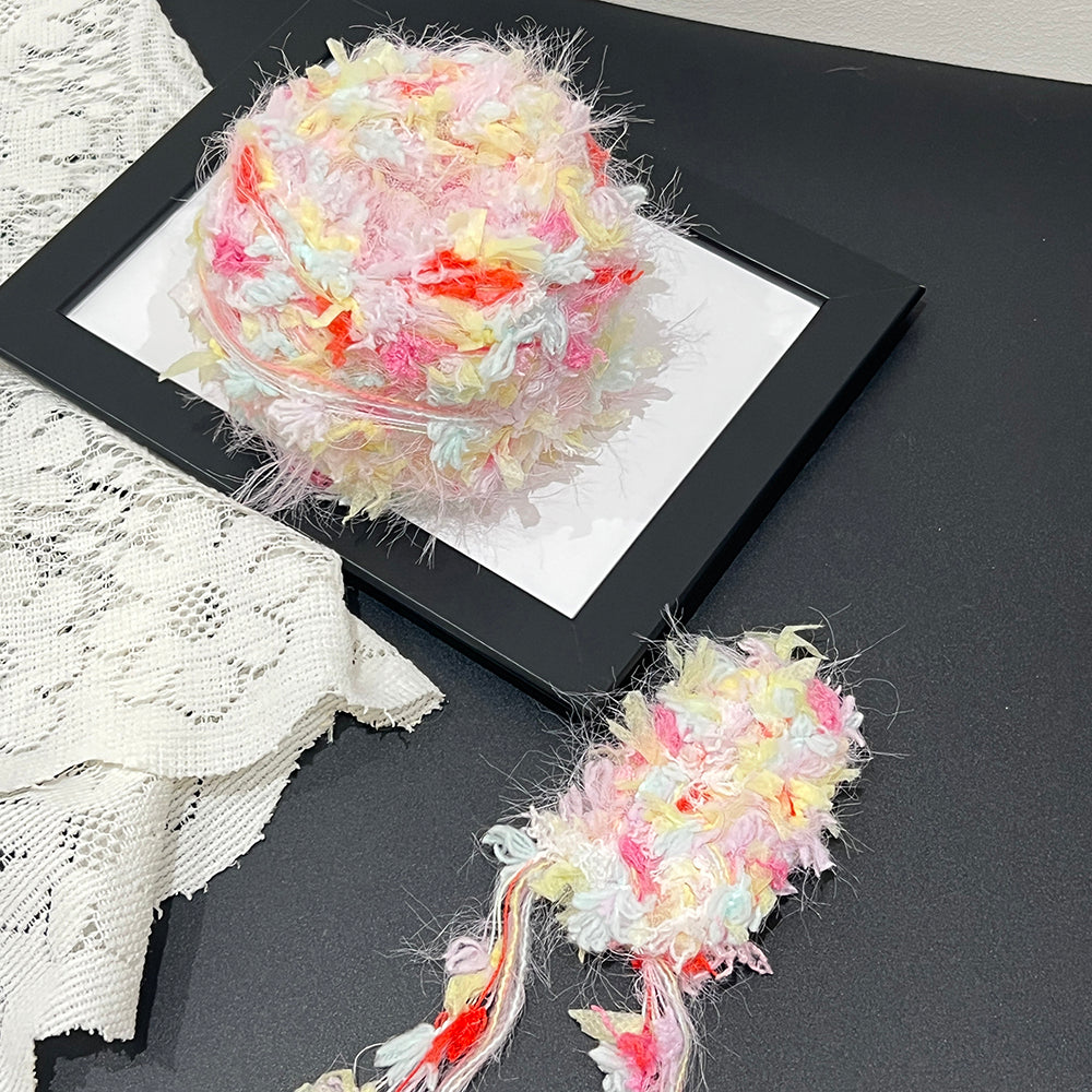 Bright candy tone cake yarn on black frame lace backdrop, whimsical colorful art yarn