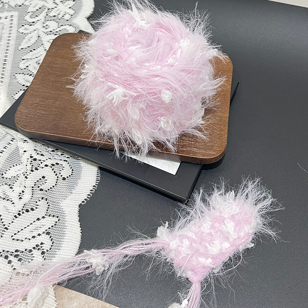 Gentle lilac pastel cake yarn laid on wooden tray with lace, whimsical textured yarn