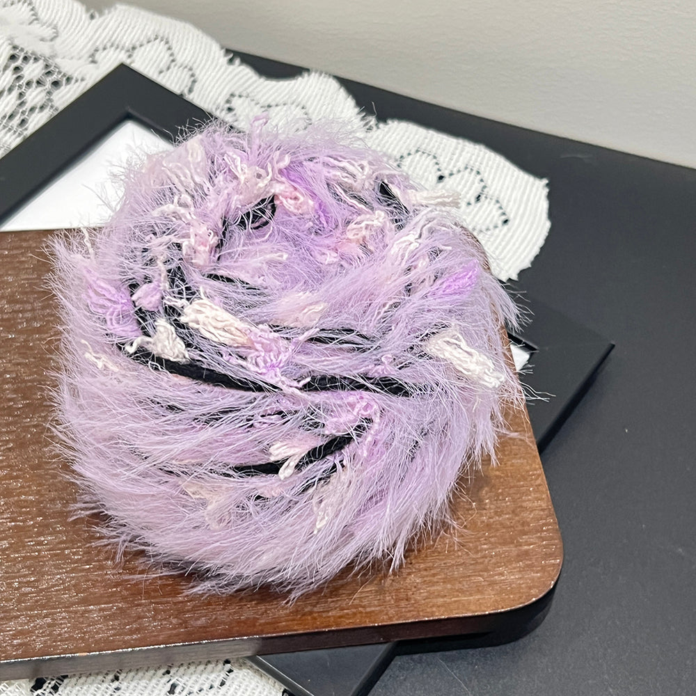 Close up thin black accent threads mixed with dusty lavender soft bobble floral fiber